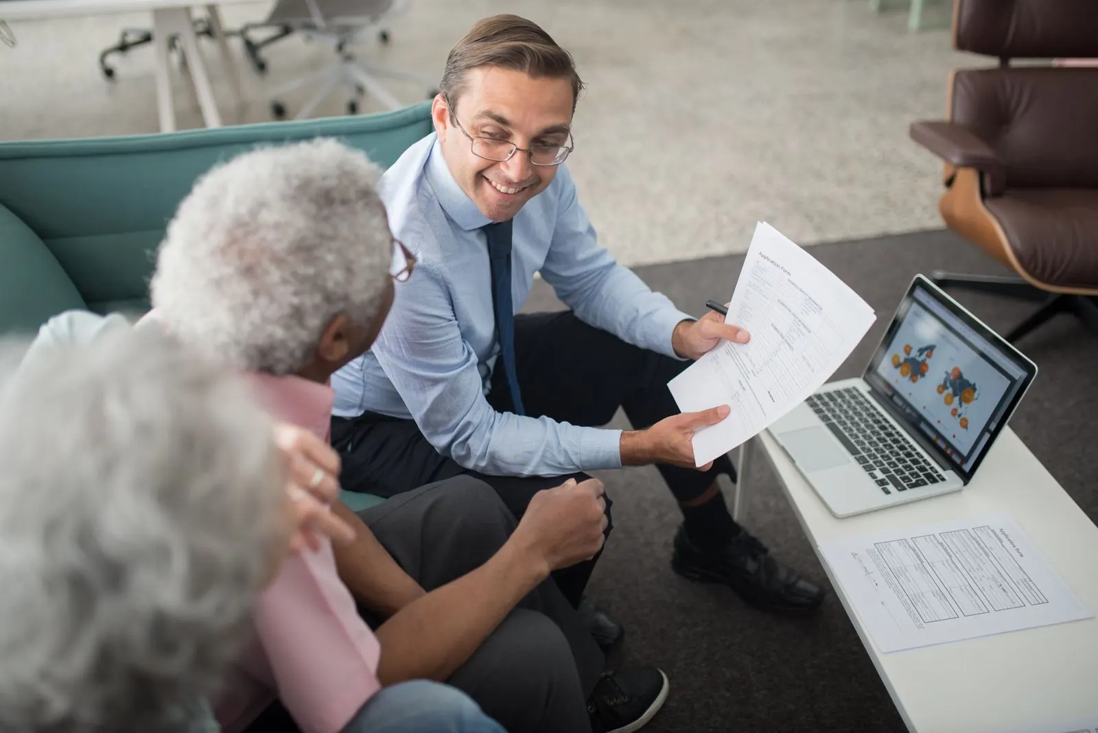 A financial adviser going through paperwork with an older couple
